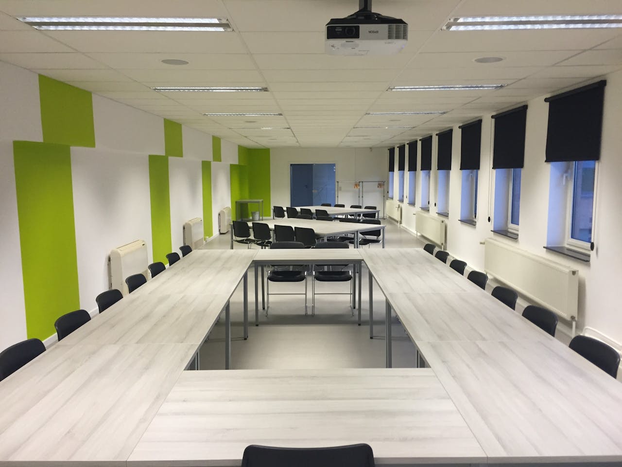 Services-02 Spacious indoor meeting room with modern furniture and large windows.
