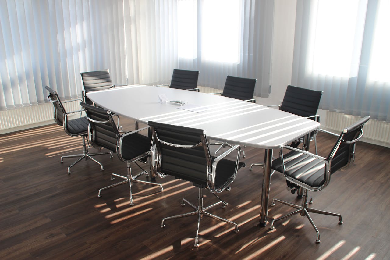 Services-01 Modern office meeting room with designer chairs, table, and large windows.